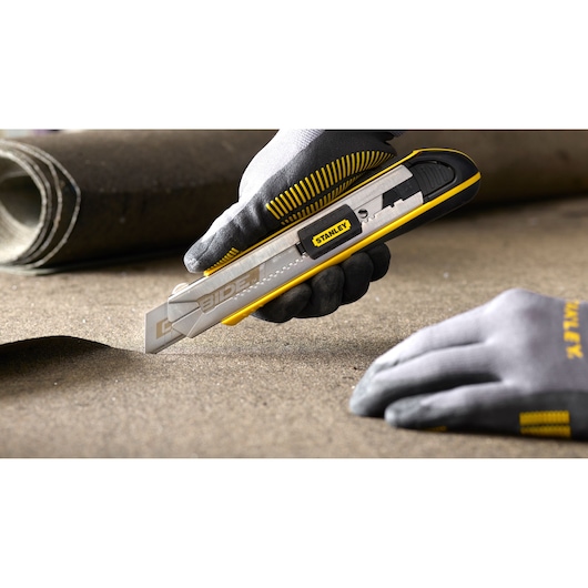 Stanley SKU 0-10-481 utility knife with silver and yellow design used on flooring material.