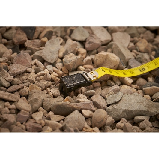 STANLEY 0-34-295 tape measure with yellow blade on rocky ground, close-up photography.