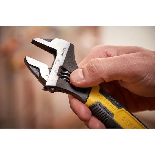 Photo of STANLEY 0-90-948 adjustable wrench with yellow and black handle held in hand.