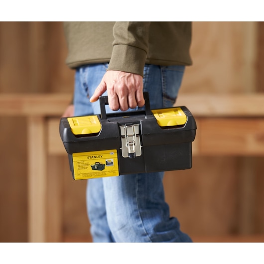 STANLEY 1-92-064 toolbox, black and yellow, carried by hand, front angle, photography product.