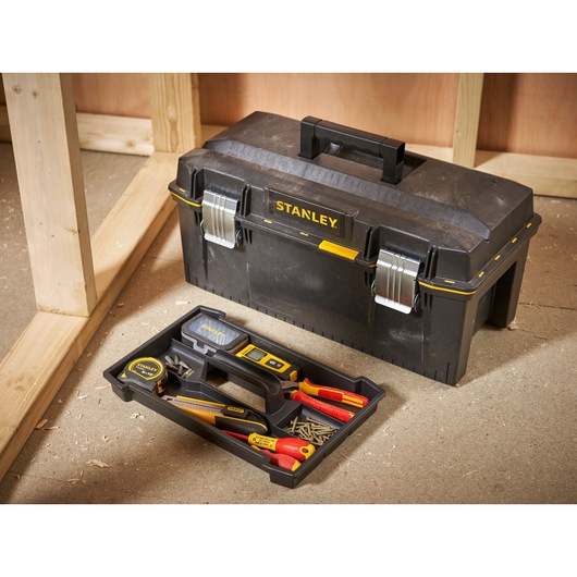 STANLEY 1-94-749 toolbox with tray of hand tools and screws on workshop floor.