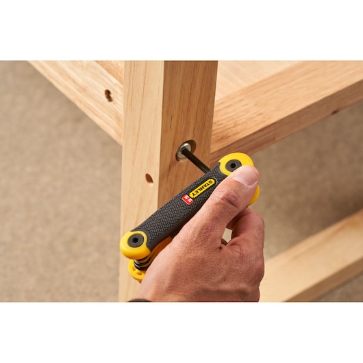 Photo of STANLEY 2-69-264 folding hex key set being used to assemble wooden furniture.