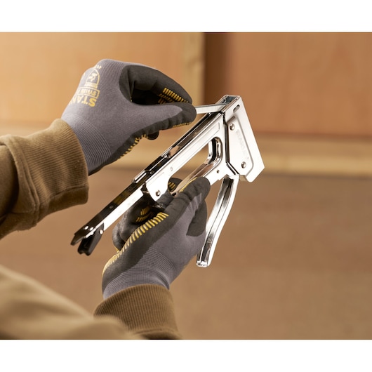 Stanley 6-TR45 photography of person loading staples into chrome staple gun.