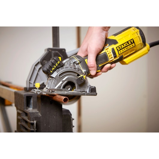 Photo of STANLEY FME380K circular saw cutting copper pipe, close-up of tool in use.