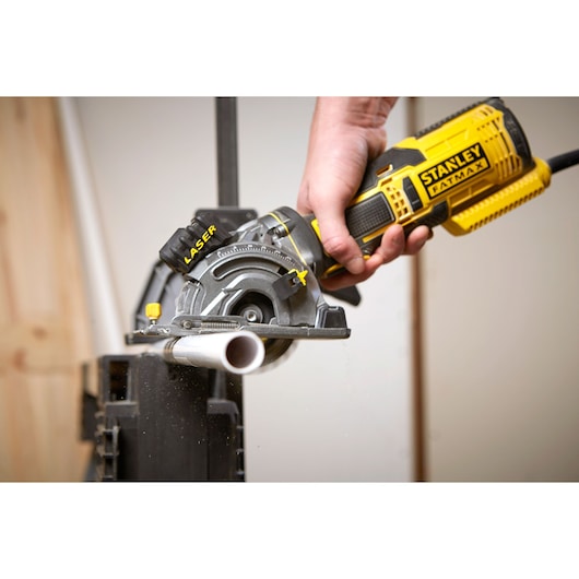 Photo of STANLEY FME380K saw cutting PVC pipe, close-up of tool in use, yellow and black design.