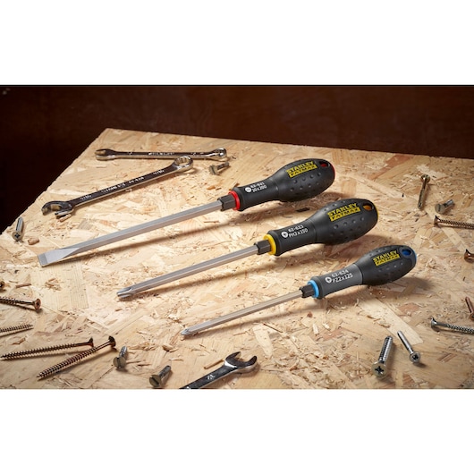 STANLEY FMHT0-62623 screwdriver set with black handles on a wooden workbench with screws and wrenches.