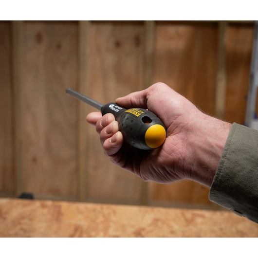 Photo of a hand holding a STANLEY FMHT0-62623 screwdriver with black and yellow ergonomic handle.