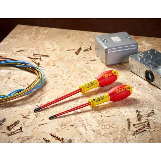 STANLEY FMHT0-62649 insulated screwdrivers on a wooden surface, surrounded by electrical wires and hardware.