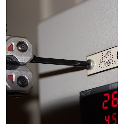 Photo of STANLEY FMHT0-72414 multi-tool screwdriver tightening a screw in a metal nameplate.