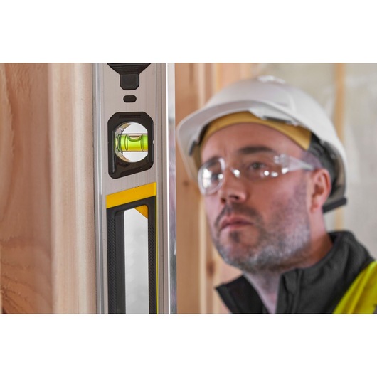 STANLEY FMHT43674-1 spirit level close-up with clear vial, photography on construction site.