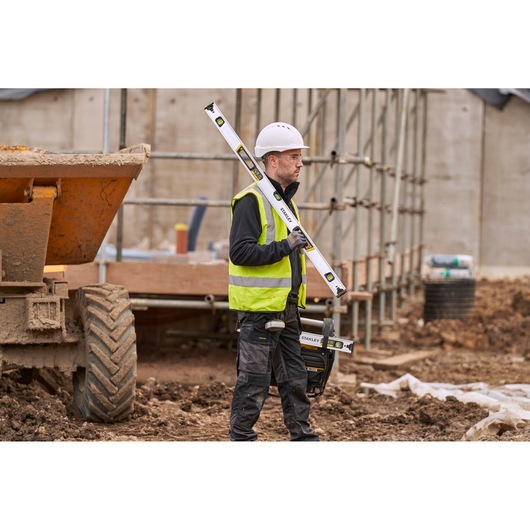 Photo of STANLEY FMHT43674-1 spirit level held by worker on construction site.
