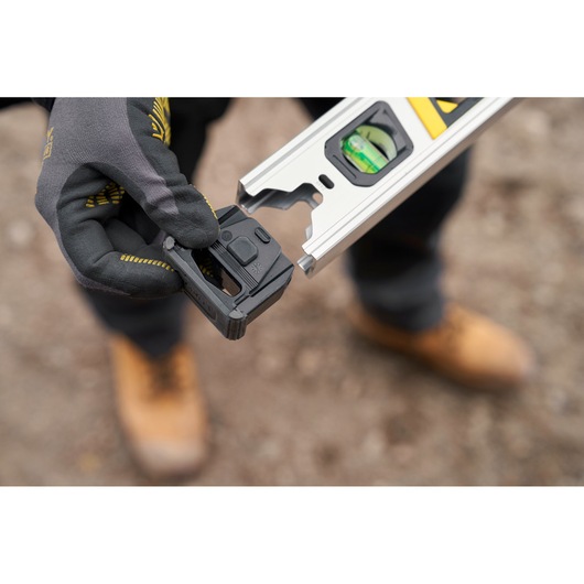 STANLEY FMHT43675-1 photography of digital level being attached by gloved hand outdoors