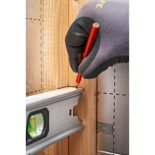 STANLEY FMHT43676-1 photography of hand marking wood with pencil beside aluminum level.