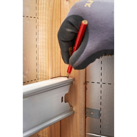 STANLEY FMHT43678-1 photography of gloved hand marking wood with red pencil near metal rail.