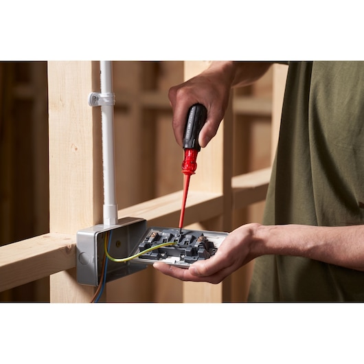 STANLEY FMHT66426-0 screwdriver used for electrical work, close-up of hand and wiring in construction setting.