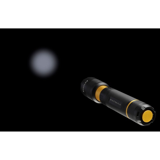 STANLEY FMHT81511-0 black and yellow flashlight side angle with beam visible in darkness.