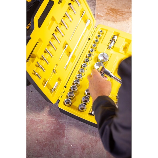 STANLEY FMMT82684-1 socket set photography, yellow case open, hand holding socket, top-down angle.