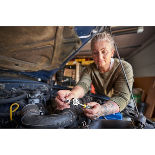 Photo of a person using STANLEY FATMAX FMMT82826-1 ratchet and socket tool on a car engine.