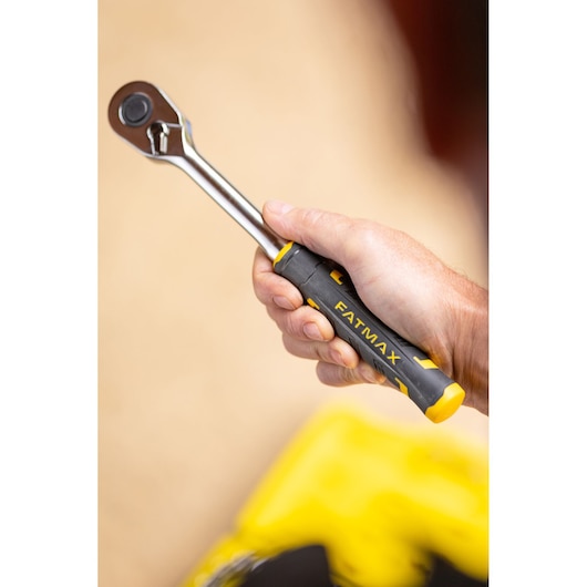 STANLEY FMMT82826-1 ratchet wrench with black and yellow FATMAX handle held in hand, close-up.