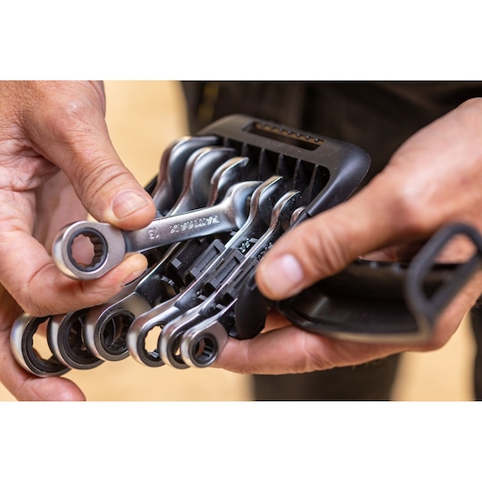 STANLEY FMMT82900-0 ratcheting wrench set in black plastic holder, close-up view, held by hands.