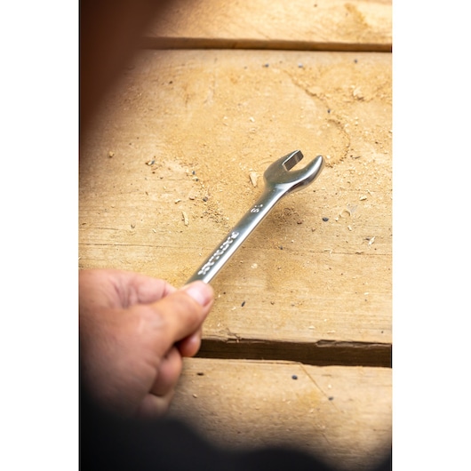 STANLEY FMMT82902-0 open-end wrench held in hand, photographed on wooden work surface.
