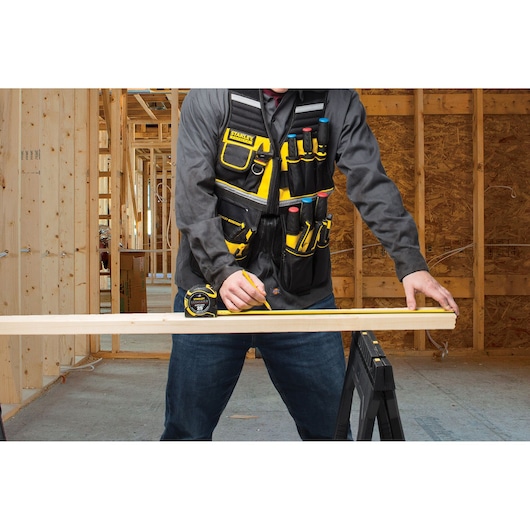 STANLEY FMST1-71181 tool vest with pockets, worn by person in construction setting.
