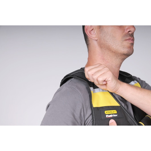 STANLEY FMST1-71181 vest close-up, yellow and black, FastMax logo, shoulder adjustment shown.