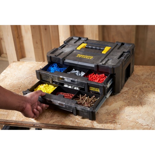 STANLEY FMST1-71969 organizer box with open drawers showing screws and colored fasteners on workbench