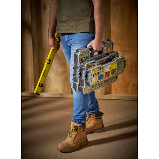 Photo of STANLEY FMST1-75781 organizer carried by person, filled with hardware, indoors on worksite.