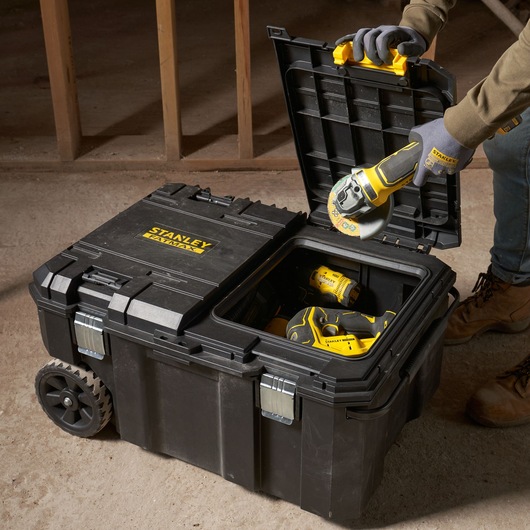 STANLEY FMST17870-1 rolling toolbox, open top view, storing power tools, on concrete floor.