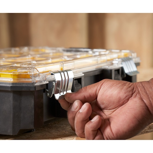 Photo of STANLEY FMST82967-1 organizer with clear lid and metal latch being opened by hand.