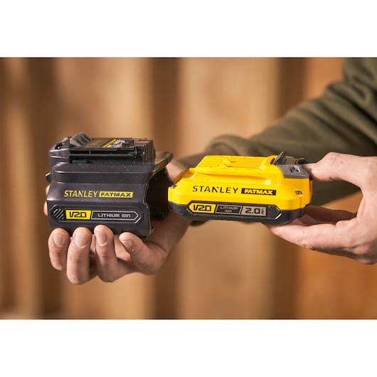 Photo of STANLEY SFMCB100 V20 FATMAX lithium-ion batteries, black and yellow, held in hands.