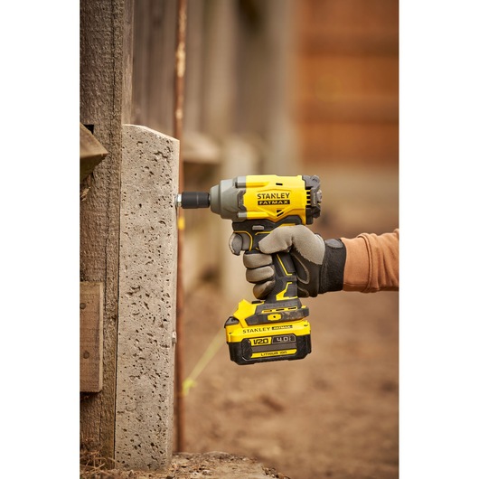 STANLEY SFMCF920B impact driver in use, yellow and black, outdoor close-up, photography category.