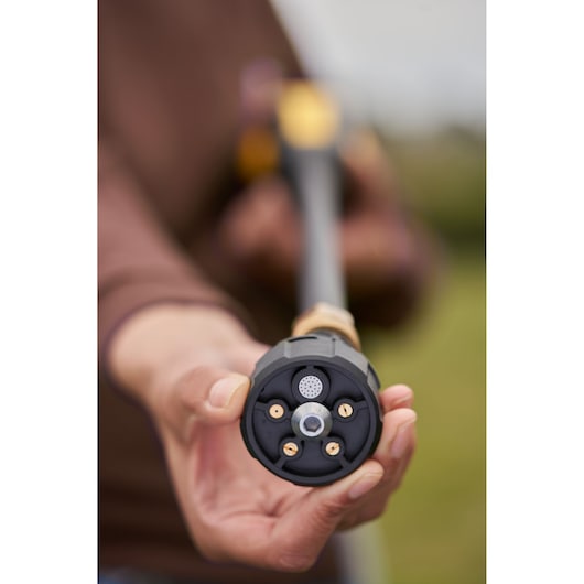 STANLEY SFMCPC93M1 multi-nozzle garden sprayer tip, close-up front view, held outdoors.