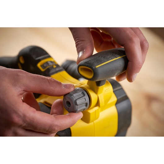 STANLEY SFMCW223B-XJ cordless planer detail, showing hand adjusting depth knob