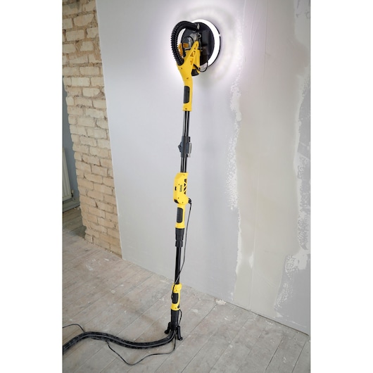 STANLEY SFMEE500S wall sander with LED light, telescopic handle, sanding plaster wall, side view.