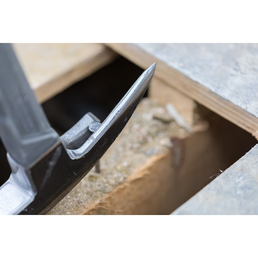Close-up photo of STANLEY STHT0-51312 claw hammer head prying near wood, product photography.