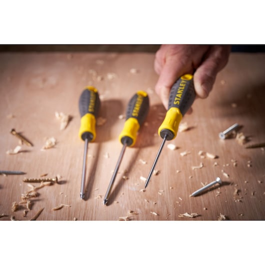 STANLEY STHT0-60358 screwdriver set with yellow and black handles on a wood surface with screws and shavings.