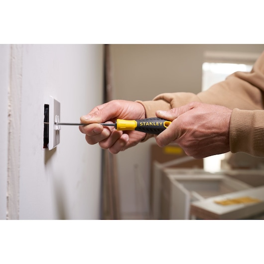 Photo of STANLEY STHT0-60358 screwdriver, yellow and black handle, used to install wall outlet.
