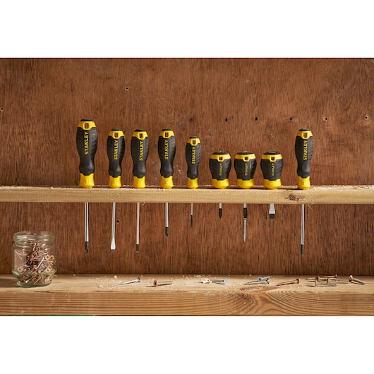 Photo of STANLEY STHT16153-0 screwdriver set, eight black and yellow screwdrivers on a wooden shelf.