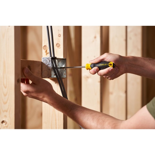Photo of STANLEY STHT16155-0 screwdriver being used to install electrical box in wooden framing.
