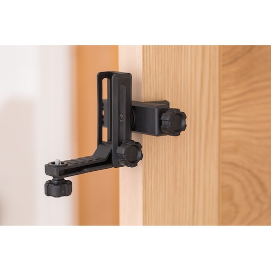 STANLEY STHT77502-1 photography door clamp mount in black, attached to a wooden door, side view.