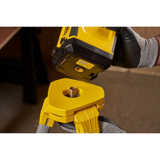 STANLEY STHT77616-0 photography of yellow laser level being mounted onto tripod base.