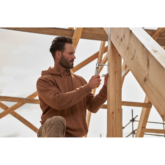 STANLEY STMT82665-0 ratchet tool used on wooden construction frame outdoors.