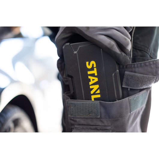 STANLEY STMT82672-0 black tool case with yellow logo in work pants pocket, close-up photography.