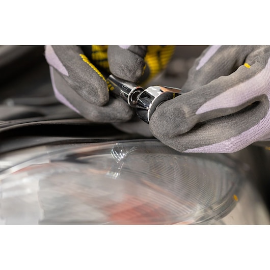 STANLEY STMT82672-0 socket being used by gloved hands near a car headlight, close-up photo.