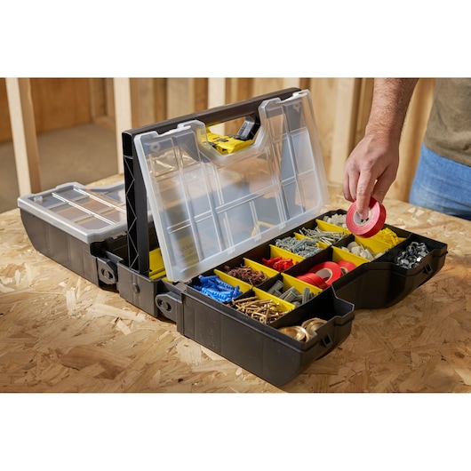STANLEY STST1-71963 organizer box with clear lid and yellow compartments, photo of hand picking red tape.