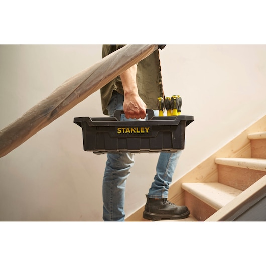 Stanley STST1-72359 black toolbox with screwdrivers, carried by person on stairs.