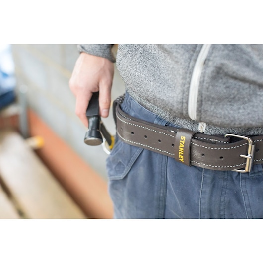 STANLEY STST1-80119 brown leather tool belt worn at waist, visible STANLEY logo, close-up side angle.