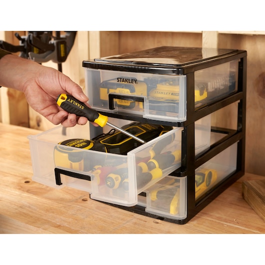 STANLEY STST40712-1 storage drawers filled with tools, photo of drawer being opened on workbench.